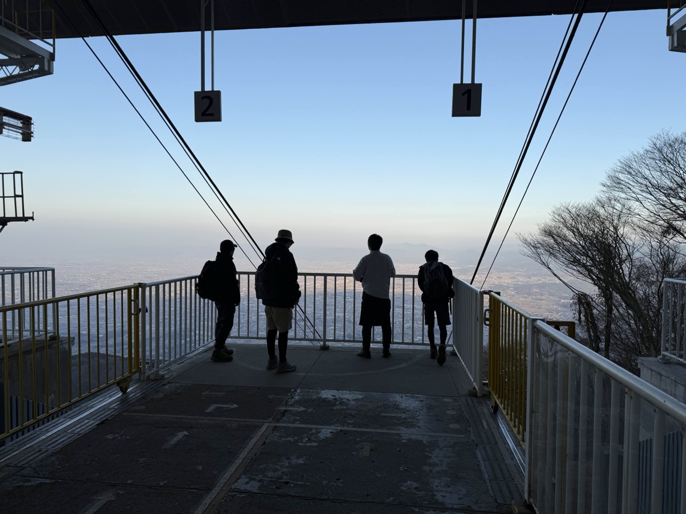 葛城山ロープウェイの山上駅から景色を眺める4人のシルエット